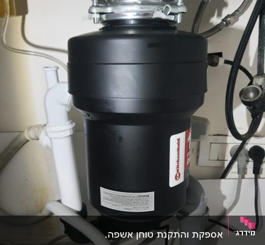 מכשיר טוחן אשפה מותקן מתחת לכיור במטבח